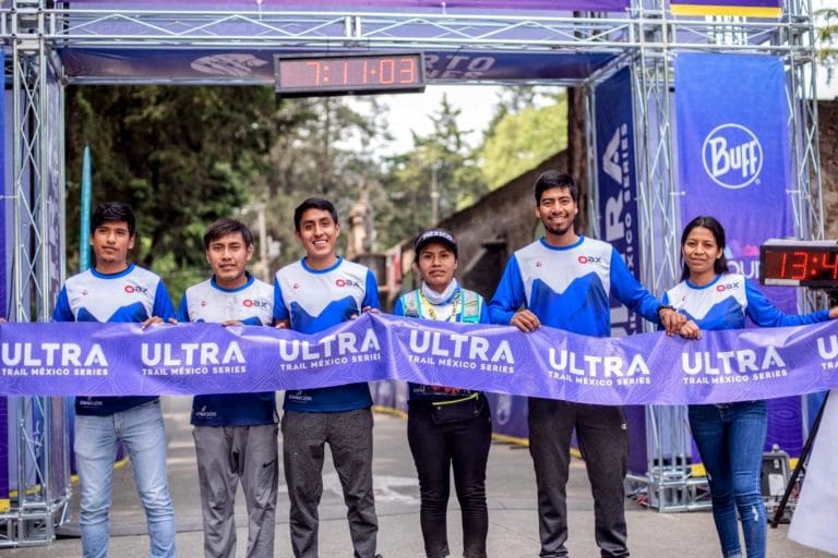 Seis corredores de Oax Sport posan en la línea de meta del Ultramaratón Desierto de los Leones, sosteniendo una cinta que dice 'ULTRA Trail México Series'
