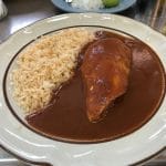 A plate of chicken mole with rice.