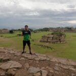 Luis Fabian Santiago, atleta de San Pablo Yaganiza, Villa Alta, Oaxaca, en la zona arqueológica de Monte Albán, Oaxaca, México, posando con la camiseta verde de Oax Sport.