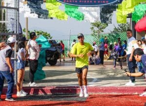 Felipe Arellanes Ruiz, atleta de Santa Catarina Cuixtla, Miahuatlán, Oaxaca, corriendo hacia la meta en una competencia mientras es aplaudido por los espectadores.