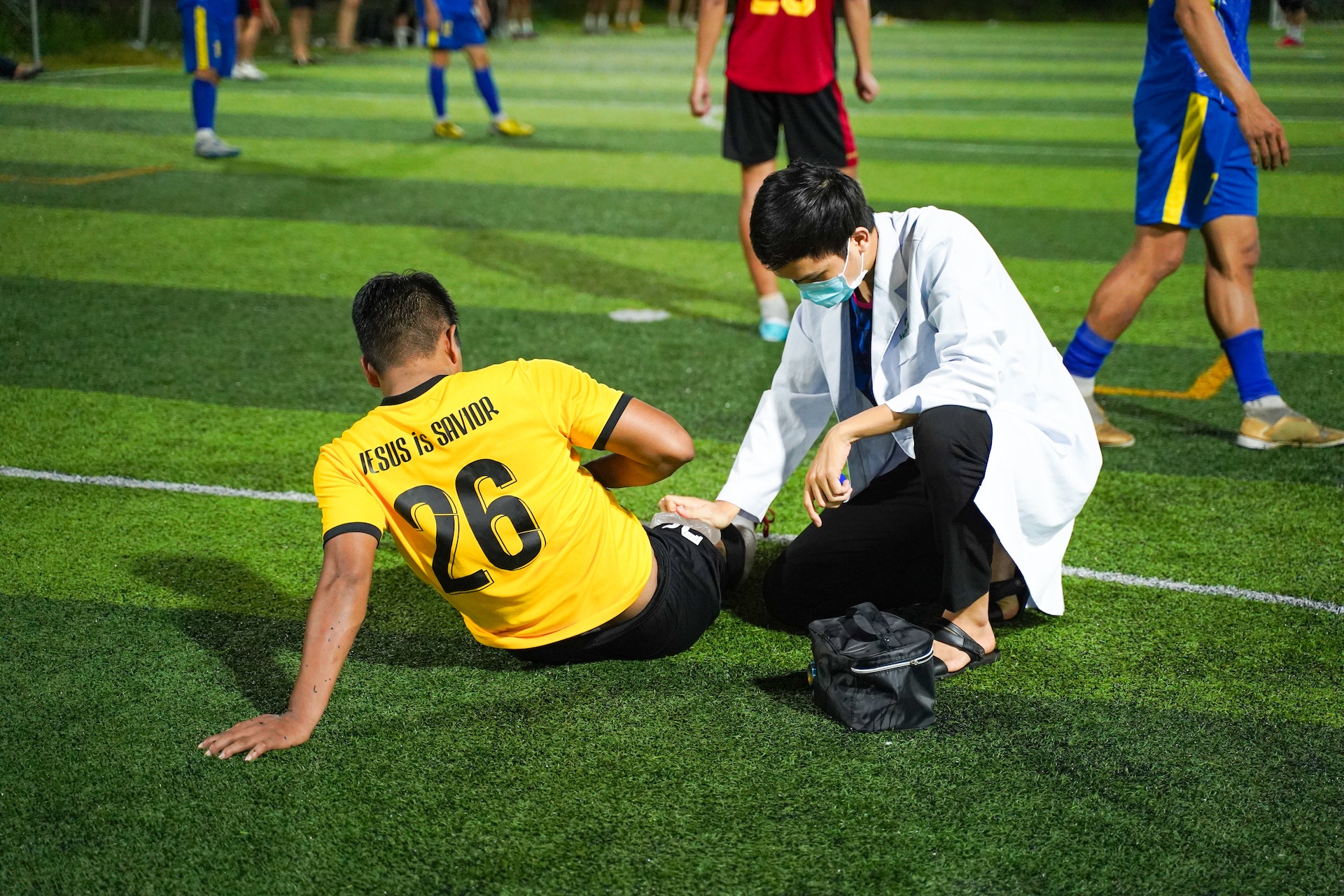 Photo by Quyn Phạm: https://www.pexels.com/photo/injured-soccer-player-with-a-doctor-13907447/