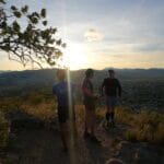 Runners standing on a hilltop, enjoying a sunrise view over Oaxaca city during the Monte Alban Sunrise Run.