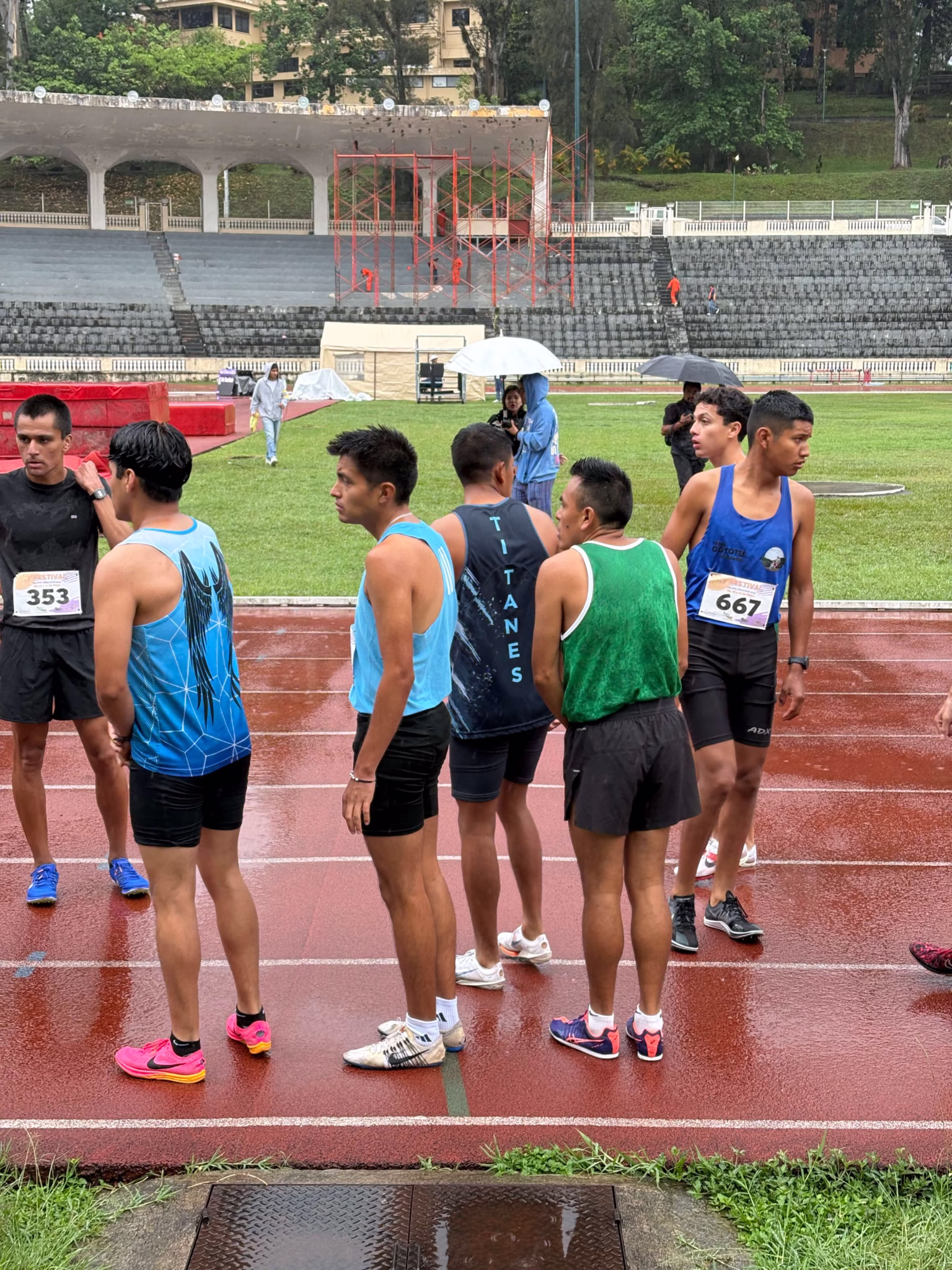 Club Titanes athletes on a rainy track preparing for competition at Xalapa 2025.