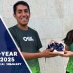 Two Oax Sport members in green shirts smiling while holding a pair of running shoes, with the text “End-of-Year Report 2025” and “Impact + Financial Summary” on the left.
