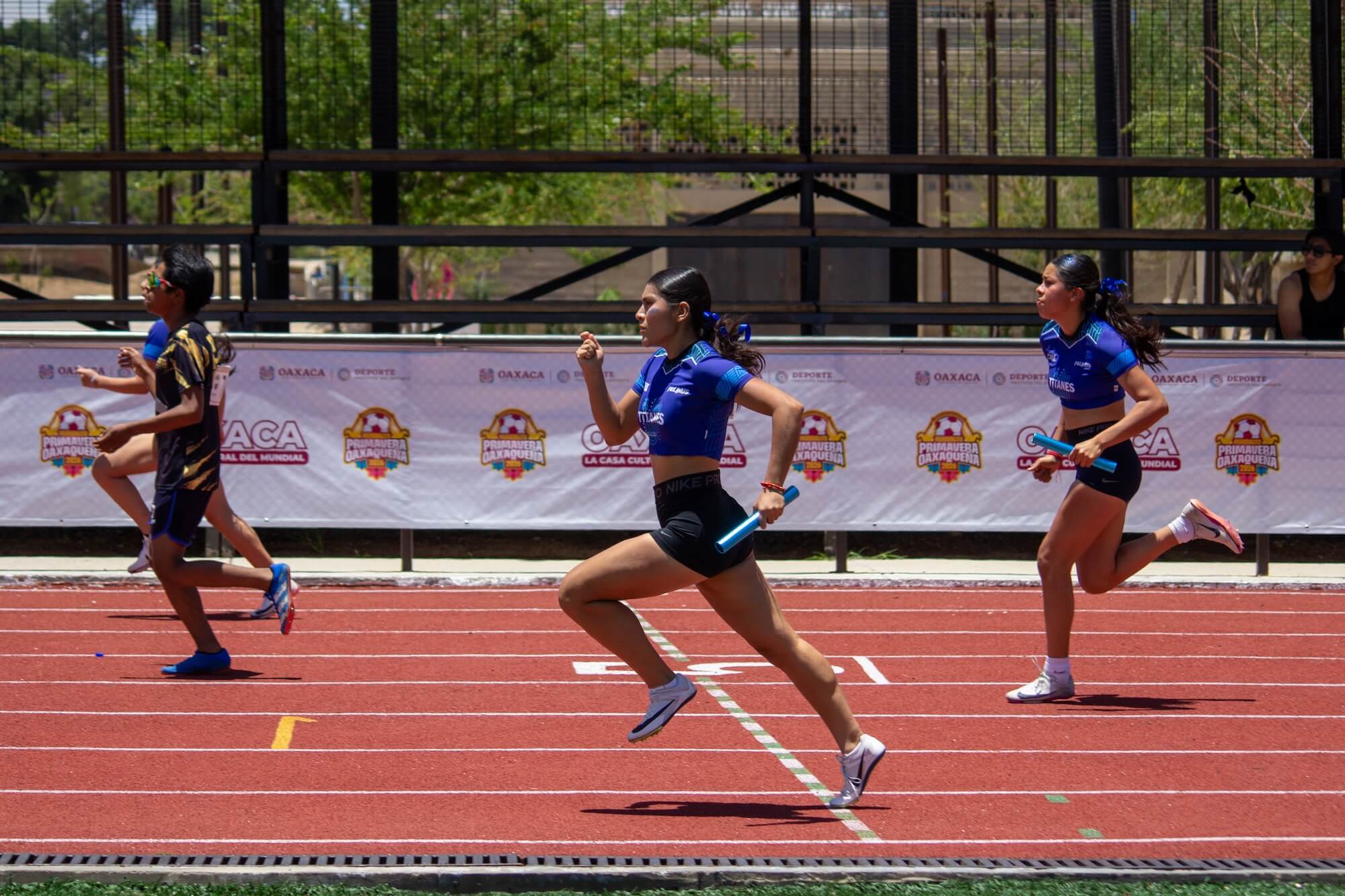 Titanes athletes run the mixed 4x100 m relay during the Festival Atlético Autotransportes Avendaño Morales 2026 at Parque Primavera.