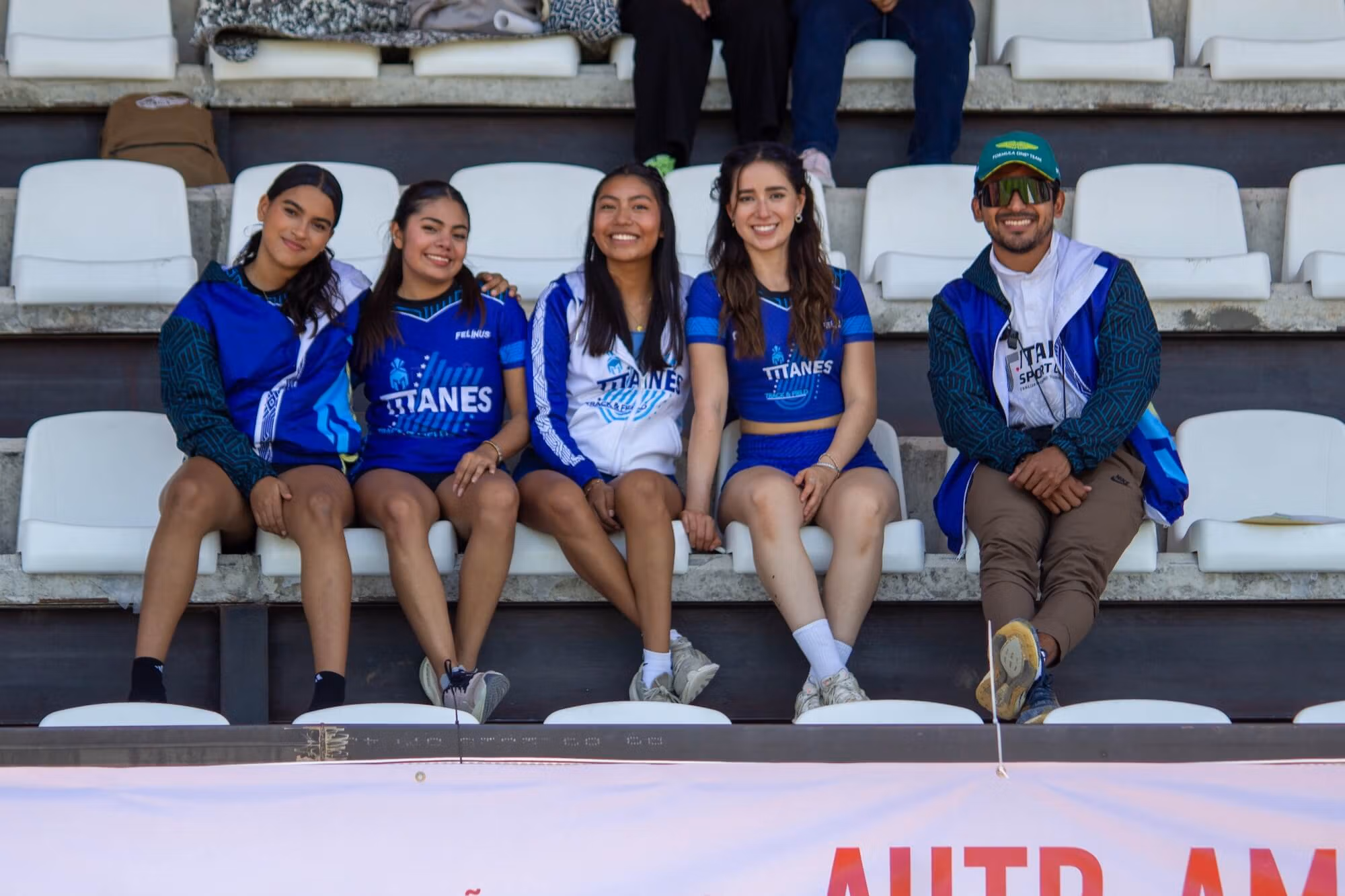 Titanes track and field team members and their coach at a meet in Oaxaca