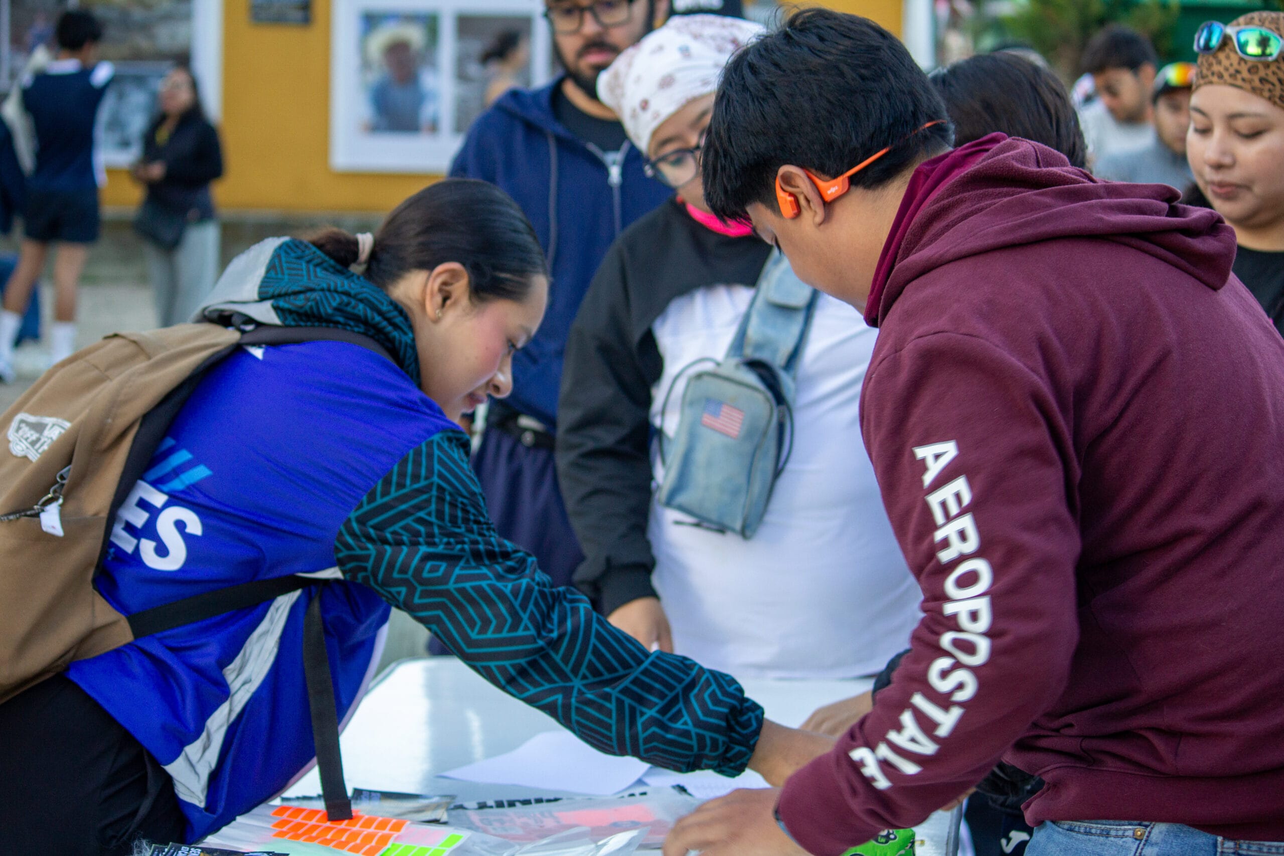 Participantes y organizadores trabajan con números y materiales de registro en una mesa antes de la carrera.