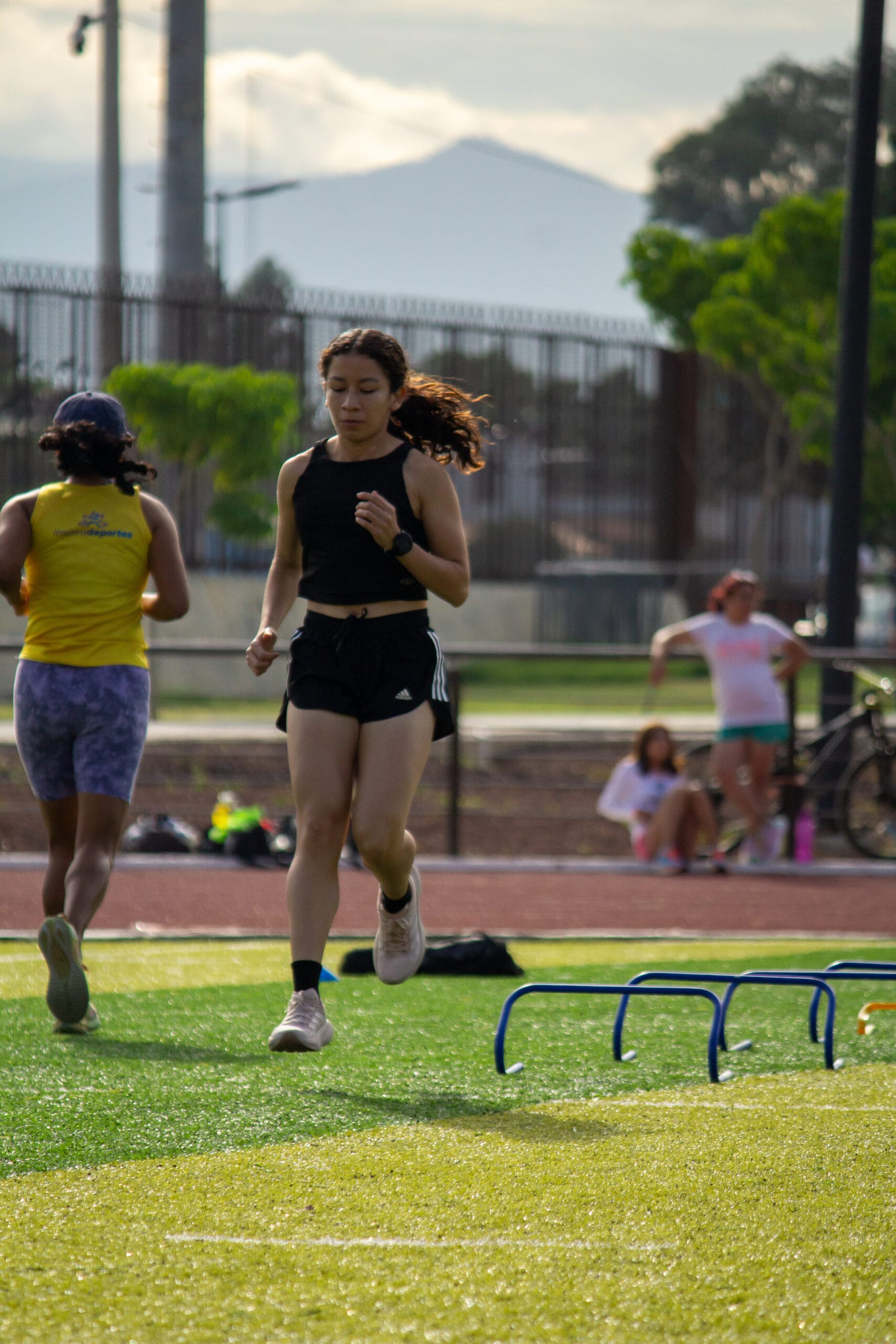 Atleta corriendo junto a vallas bajas durante una sesión de pista del campamento de atletismo 2026 en Oaxaca.