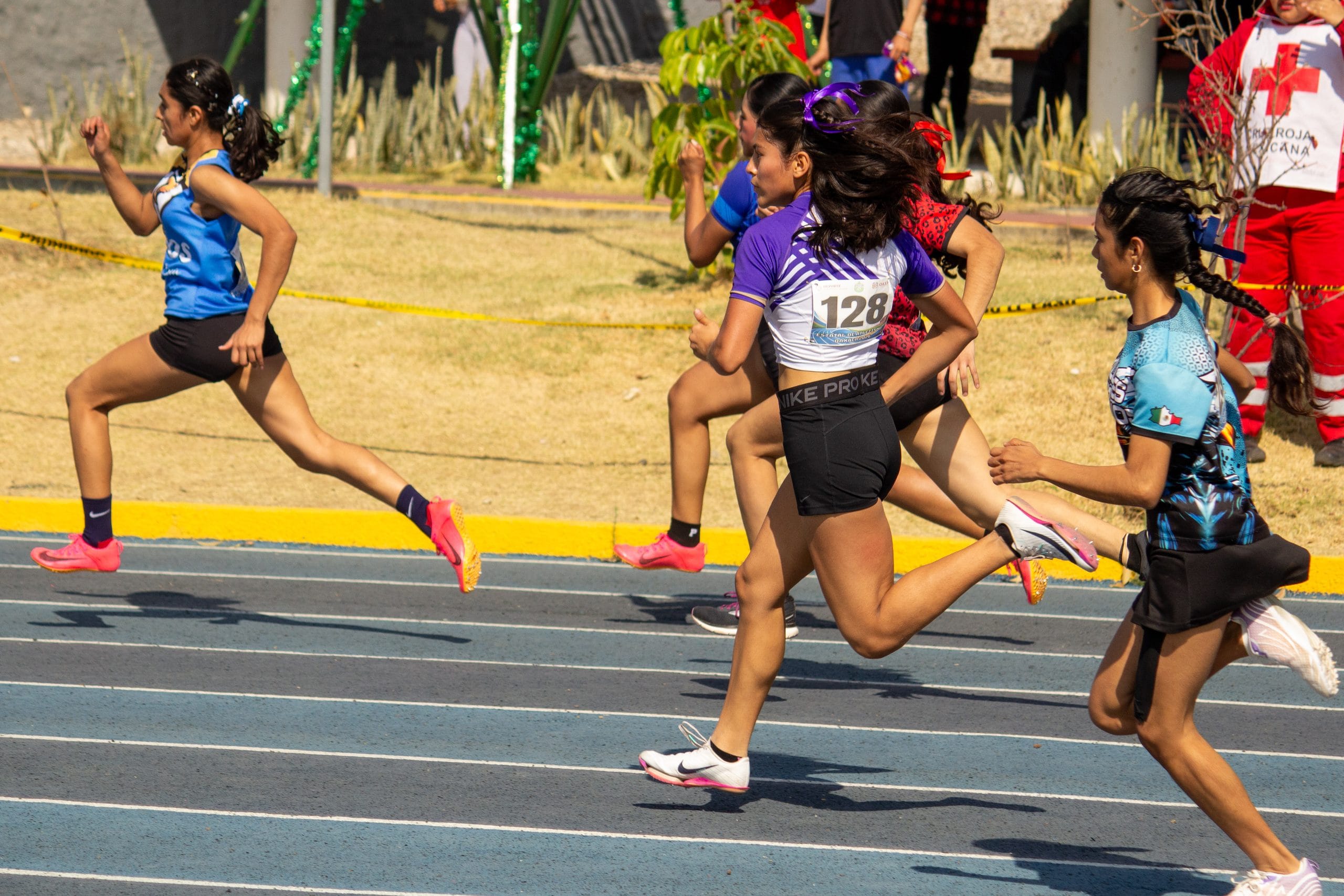 Group of athletes racing down the track at a national qualifying competition