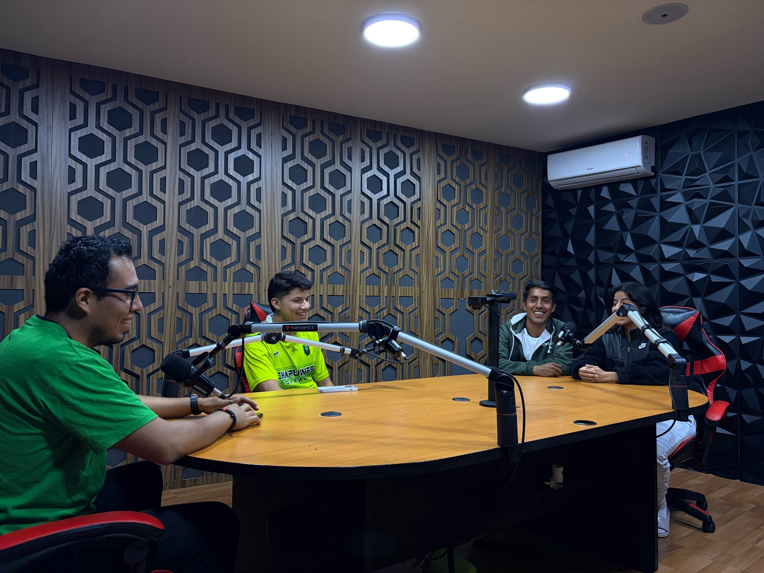 Cuatro personas riendo frente a los micrófonos durante el programa de radio Tribu al Extremo